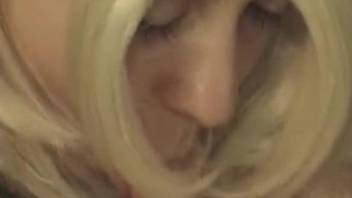 Wig-wearing blonde sucking on a pooch's perfect penis